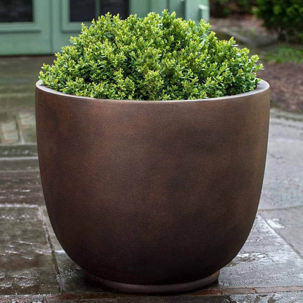 Danilo Planter, Small in rust lite on concrete filled with plants.