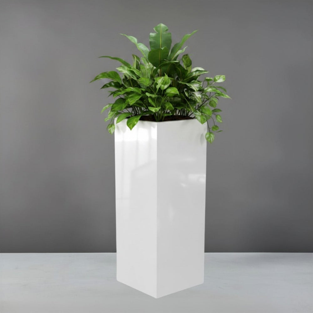 Delray Tall Corner Fiberglass Planter filled with plants against gray backdrop.