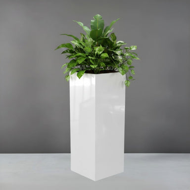 Delray Tall Corner Fiberglass Planter filled with plants against gray backdrop.