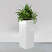Delray Tall Corner Fiberglass Planter filled with plants against gray backdrop.