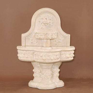 Deruta Lemon Wall Fountain against brown background.