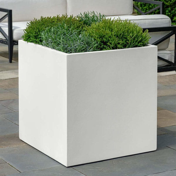 Farnley Planter 1818 S/1 in chalk lite on concrete filled with plants.