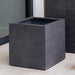 Farnley Planter 3636 S/1 in charcoal premium lite on concrete beside glass wall.