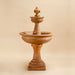 Fleur de Lis Two Tier Fountain against brown background.