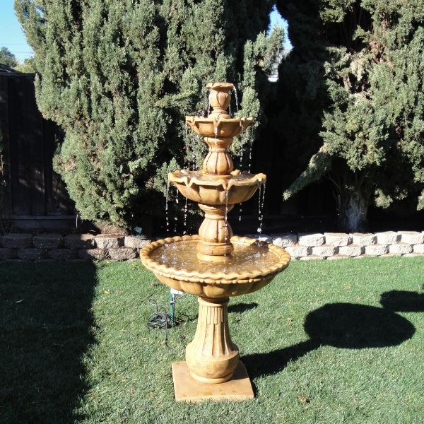 Gaetana Three Tier Fountain on grass in the backyard.