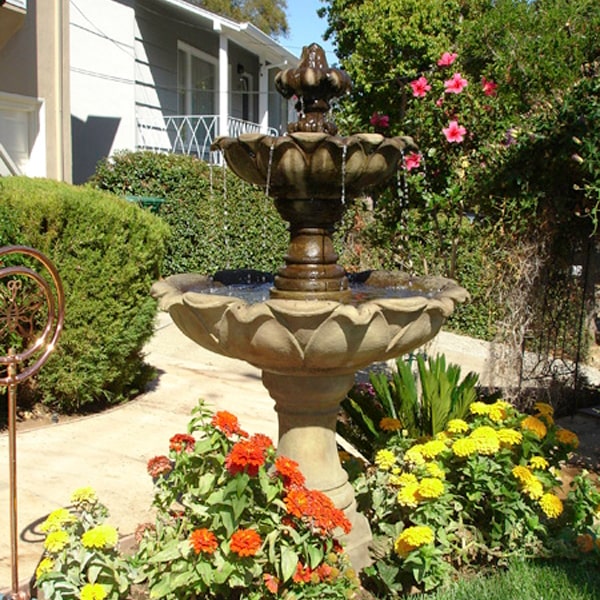 Gardenia Two Tier Fountain in action surrounded with flowers.