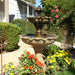 Gardenia Two Tier Fountain in action surrounded with flowers.