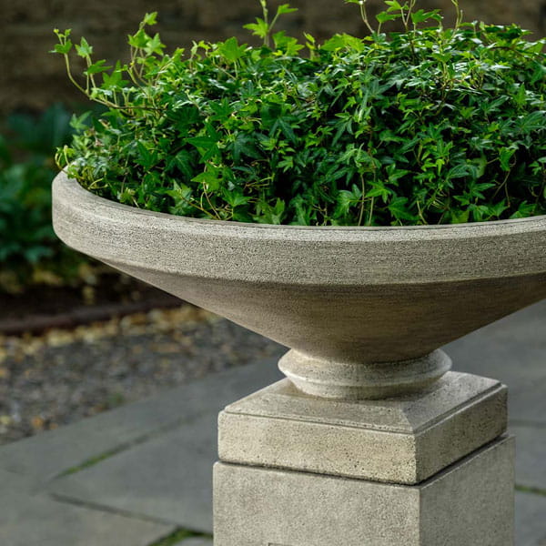 Gimlet Urn Planter filled with plants in the backyard.