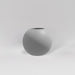 Globe Fiberglass Planter in matte cement grey against gray background.