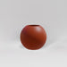 Globe Fiberglass Planter in matte terra cotta against gray background.