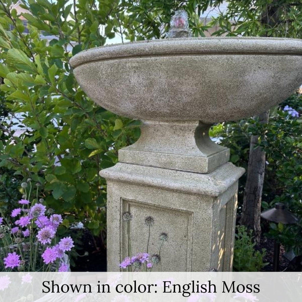 Gramercy Fountain in action beside purple flowers upclose.