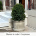 Gramercy Planter filled with plants beside concrete stairs.