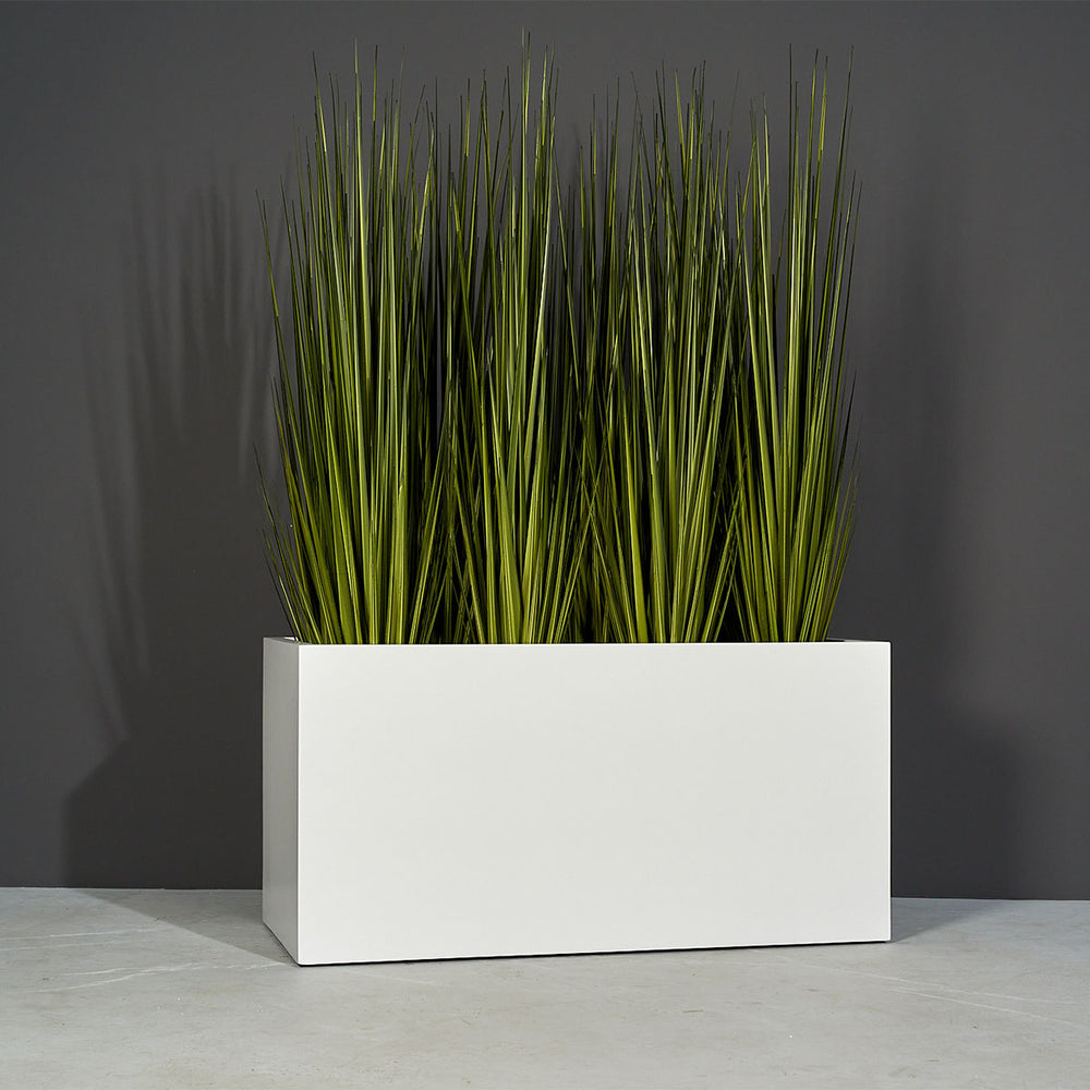 Granada Wide Rectangle Fiberglass Planter on concrete filled with plants.