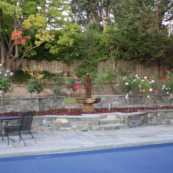 Grand Avignon Courtyard Fountain in the garden near a swimming pool.