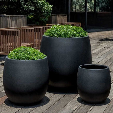 Guilford Planter, Small in onyx black lite on concrete filled with plants.
