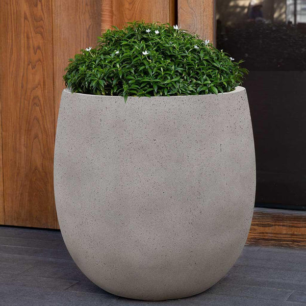 Guilford Planter, Small in stone grey lite on concrete filled with plants.