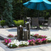 Hollowed Out Basalt Fountain Kit on black pebbles surrounded with white and pink flowers