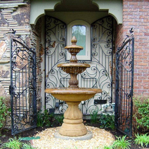 Isola Three Tier Fountain on white pebbles in the backyard.
