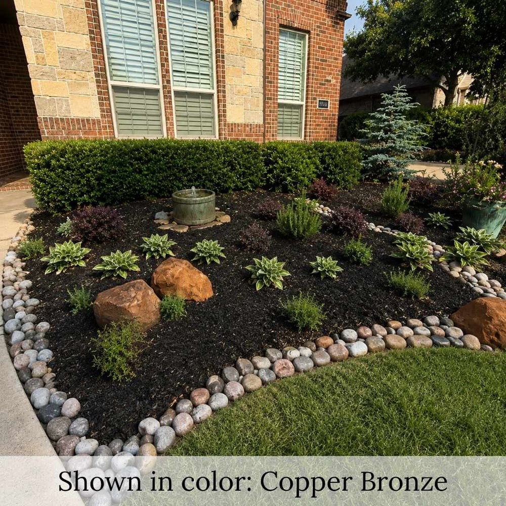 Juliet pedestal birdbath with decorative bird perched on the basin surrounded by lush shrubs in a landscaped garden.