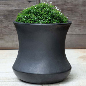 Jura Planter, Tall - Graphite - S/1 on concrete filled with plants