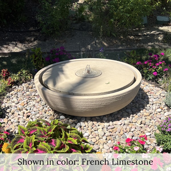 Large Girona Fountain in rock garden surrounded by flowers.