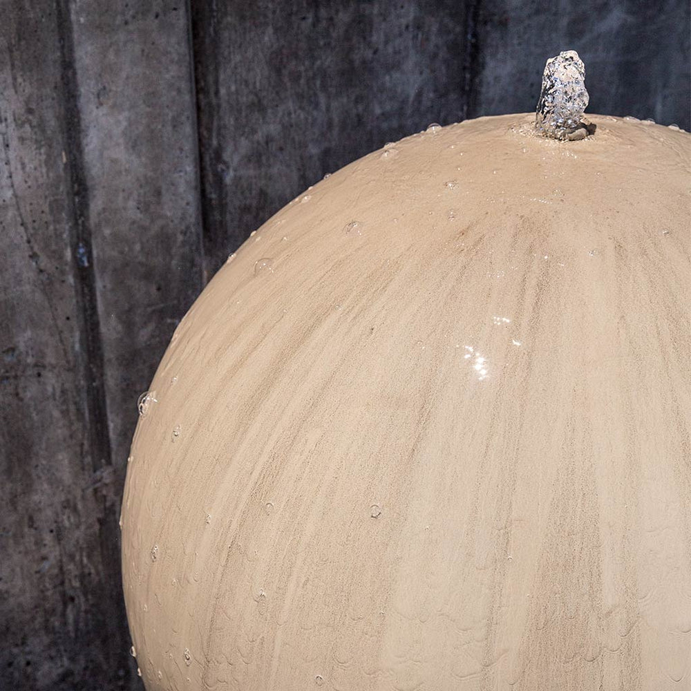 Large Sphere Bubbler Water Fountain in action on crushed gravel upclose.