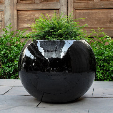 Le Monde Planter on concrete filled with plants.