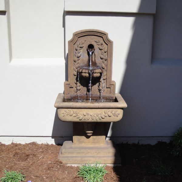 Lemon Lavabo Wall Fountain in action against concrete wall.