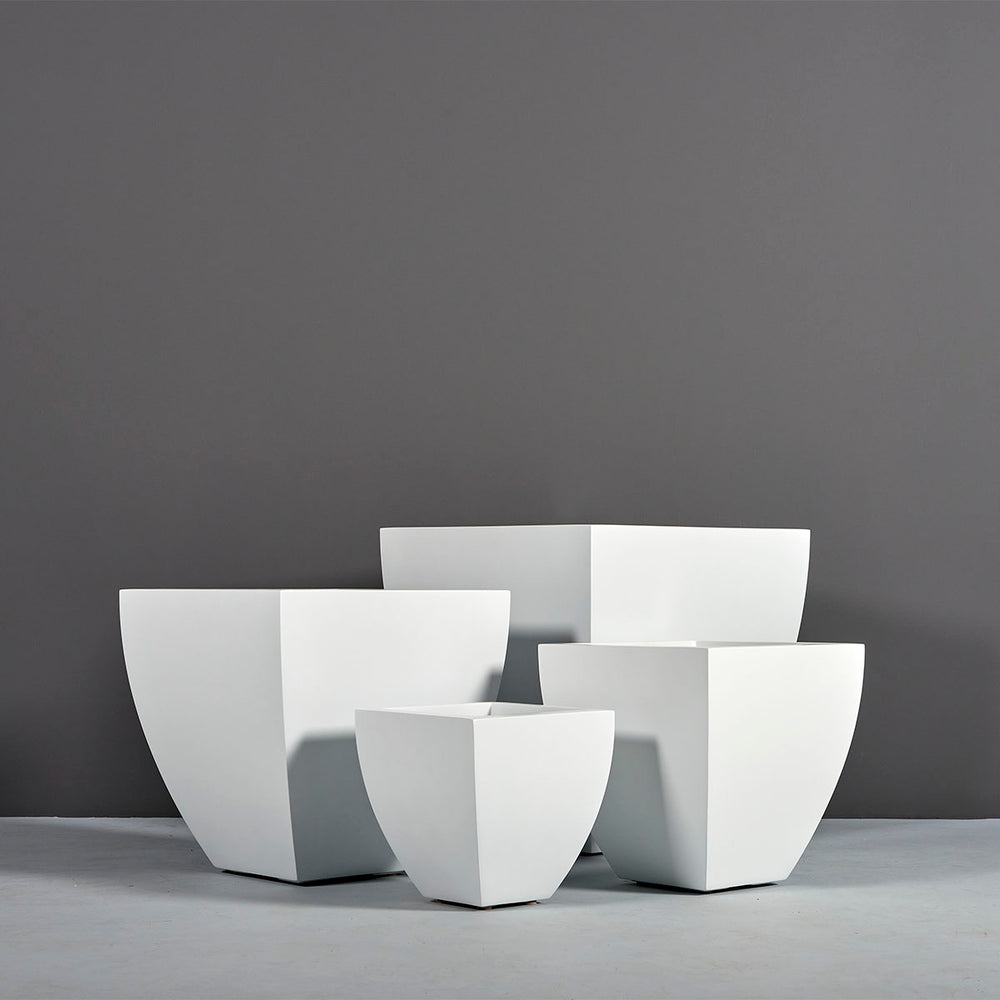 Lima Square Tapered Fiberglass Planter on concrete shown with different sizes.