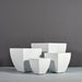 Lima Square Tapered Fiberglass Planter on concrete shown with different sizes.