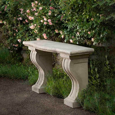 Loire Table on concrete against wall with pink flowers