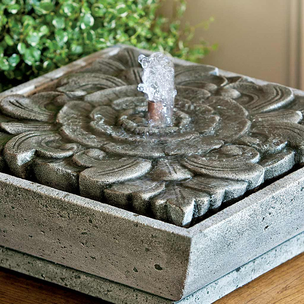  M-Series Artifact Fountain on table against green plants upclose.