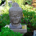 Meditation Buddha Fountain, Tall in action against green leaves.