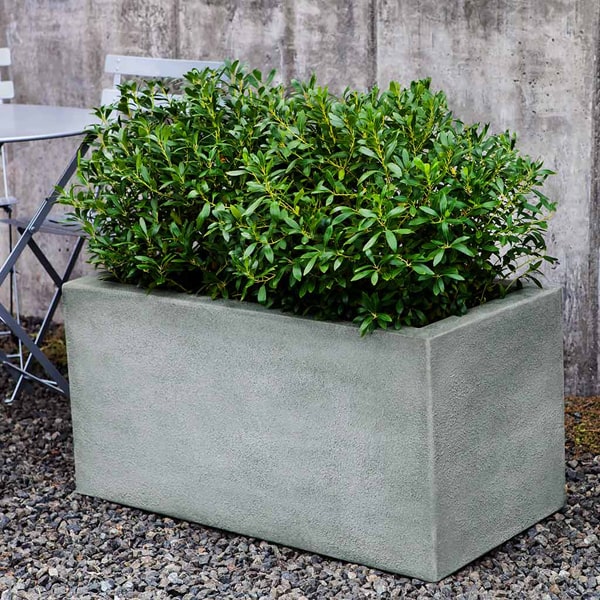 Metropolis Rectangle 482424 Planter on gravel filled with plants