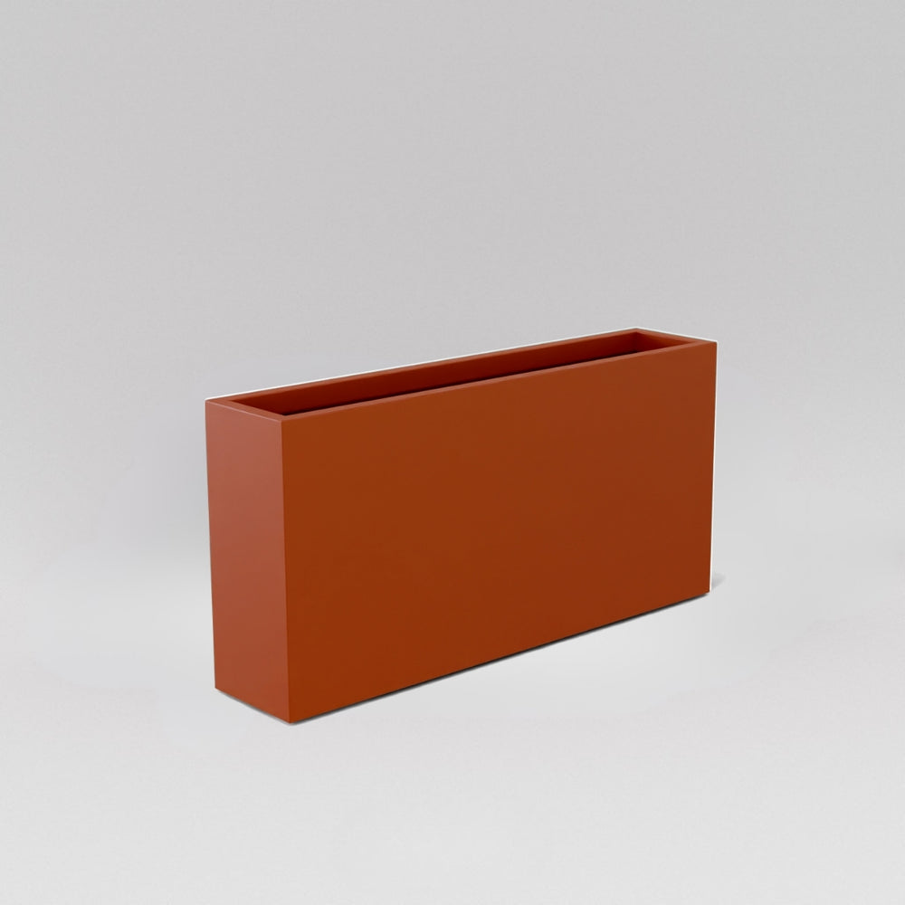 Milano Narrow Rectangle Planter in matte terracotta against gray background.