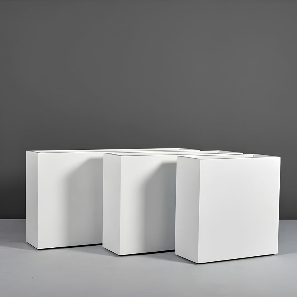 Milano Narrow Rectangle Planter on concrete against gray wall.