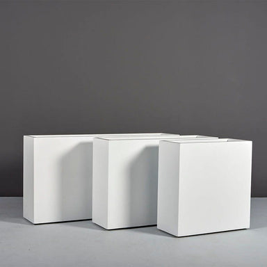 Milano Narrow Rectangle Planter on concrete against gray wall.