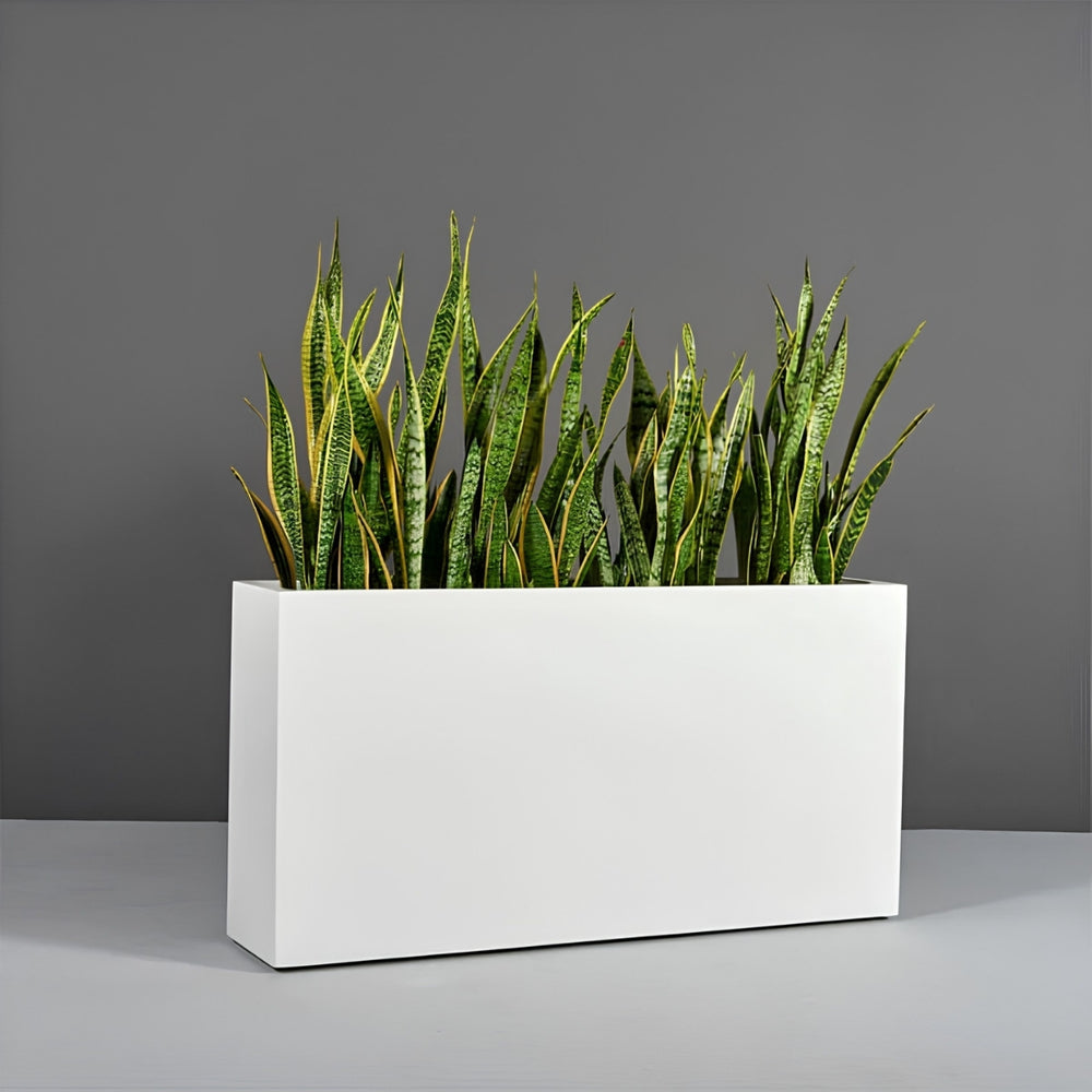 Milano Narrow Rectangle Planter on concrete filled with plants.