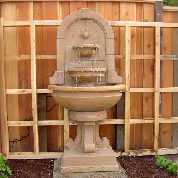 Montefalco Wall Fountain in action against wooden fence.