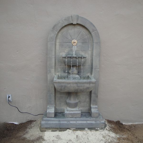 Monterosso Wall Fountain in action against concrete wall.