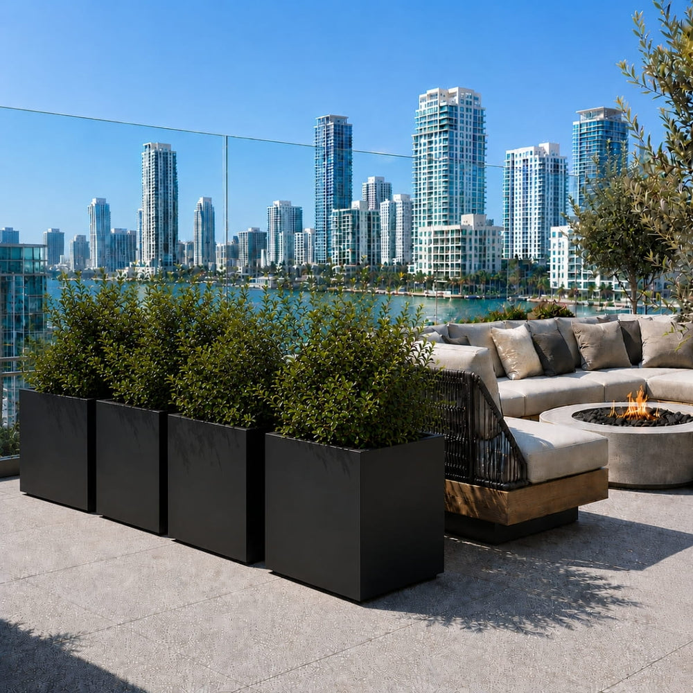 Montroy Cube Planters in matte black privacy framing a luxury rooftop lounge area with skyline and waterfront views