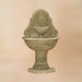 Oliva Wall Fountain against brown background.