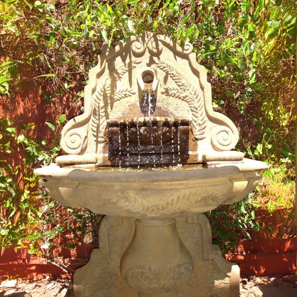 Olive Grove Wall Fountain in action in the garden.