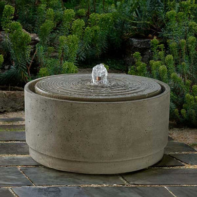 Onda Fountain on concrete with plants background