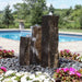 One Side Polished Basalt Fountain Kit on black pebbles near swimming pool