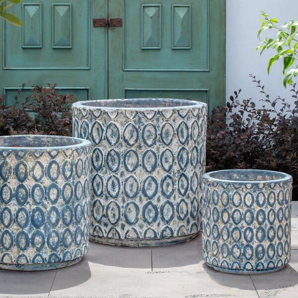 Oriel Planter in glazed murano blue on concrete in the backyard.
