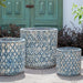 Oriel Planter in glazed murano blue on concrete in the backyard.