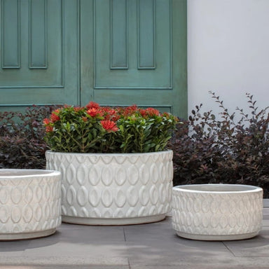 Oriel Planter, Low in glazed antique white on concrete filled with plants.