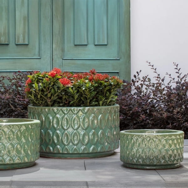 Oriel Planter, Low in glazed sea green on concrete filled with plants.