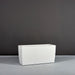 Panama Tapered Rectangle Planter on concrete filled with plants against gray background.